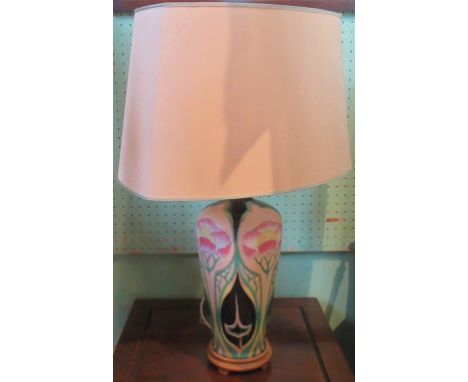 A contemporary table lamp, with floral and stylized decoration, with cream shade.