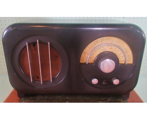 An Ekco AC85 radio. Condition Report: Overall condition good.  Large patch repair to top cloth grille has damaged knobs.  Dia