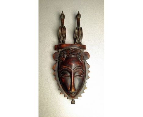 Portrait mask w/ birds. Yaure people. Ivory Coast, Africa. Wood with darkened surface. Size: 18 x 7.25 in. In very fine condi