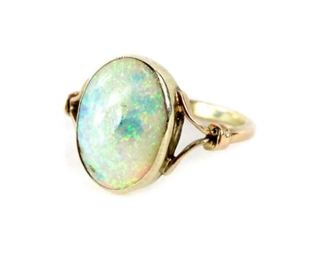 An opal dress ring, with oval cut opal stone, and v split design shoulders, in yellow metal setting, unmarked, ring size M, 2