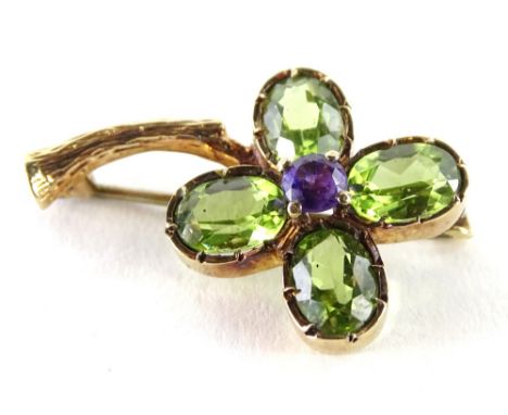 A modern 9ct gold four leaf clover brooch, set with four peridots and one amethyst stone, in the form of a four leaf clover, 