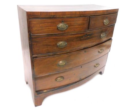 An early 19thC mahogany bow fronted chest of drawers, the caddy top above a two short and three long drawers, each with oval 