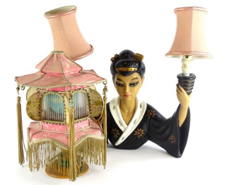 A 1950s painted composition two branch table lamp, modelled in the form of an oriental lady holding the fittings, dressed in 