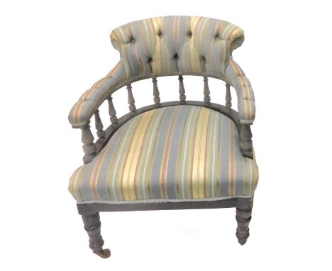 An Edwardian button back armchair, upholstered in striped fabric on square tapering legs with brass castors.