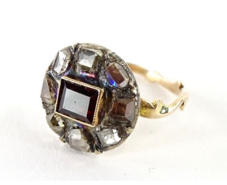 A Victorian cluster ring, with central baguette cut ruby, in gold setting, with various old cut diamonds surround, on a vine 