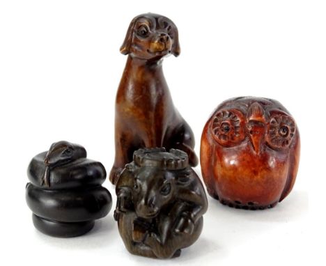 Four oriental carved wooden netsuke, to include one carved in the form of a cow or beast, a dog, a snake and an owl.