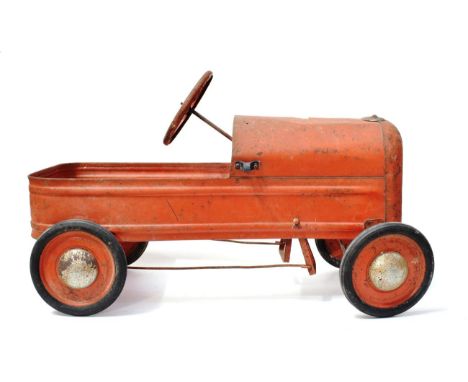 An Early 20th Century Red Painted Pedal Car, modelled as a tractor, with four-spoke steering wheel and rubber tyres, 77cm lon