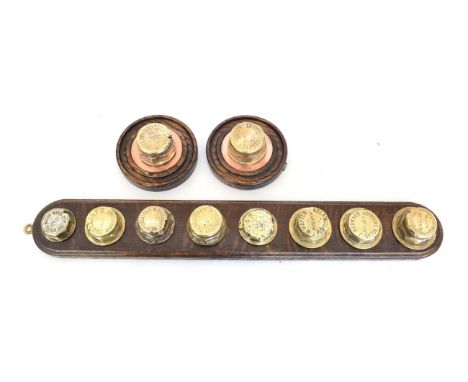 Eight Early 20th Century Brass Hub Spinners, mounted on an oak plaque, to include: Bristol wagon, Mulliner, M Rogers, Henry W