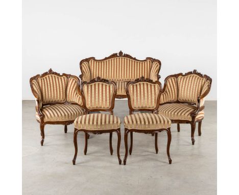 A Salon Suite, sculptured wood in Louis XV style.&nbsp;A two-seater sofa, two armchairs and two chairs.&nbsp;Dimensions: (L:7