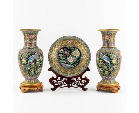A three-piece mantle garniture, openworked cloisonné enamel. Two vases and a plate.Decorated with a floral decor, and images 