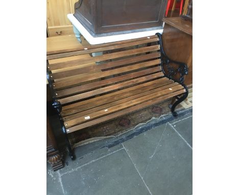A garden bench with cast iron ends and wooden slats. 