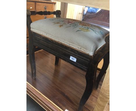 A piano stool with a tapestry seat. 