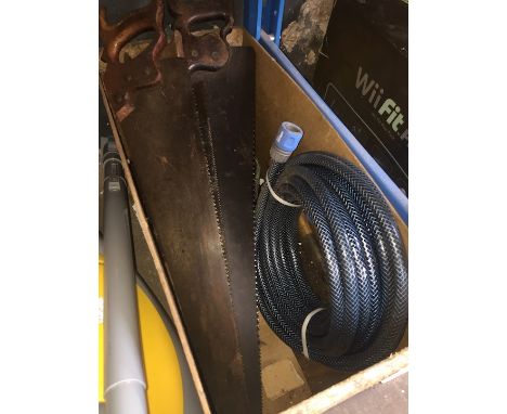 A box containing hand saws and a garden hose 