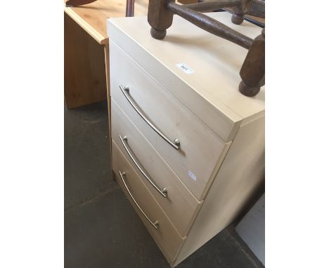A light wood effect bedside chest of three drawers. 