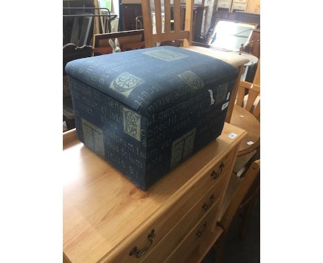 A blue patterned foot stool/box. 