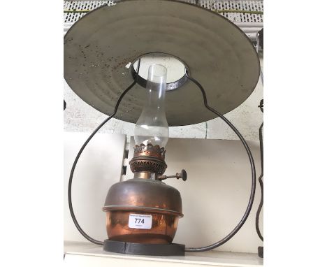 A copper parafin lamp with wrought iron support and with glass funnel 