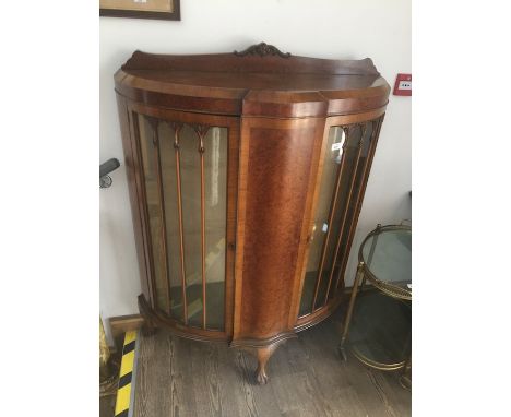 A walnut bow front two door glass display cabinet, labelled 'Wolfe's of Birkenhead', width 102cm, depth 38cm &amp; height 133