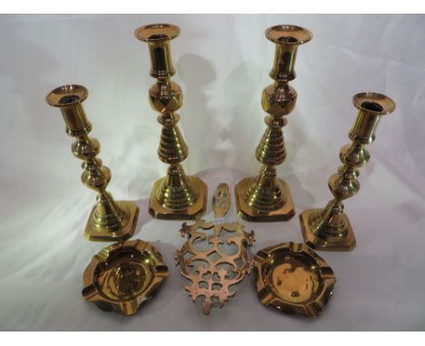 4x Brass candlestick holders, 1x brass trivet and 2x brass ashtrays.