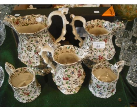 A set of three graduated Victorian ceramic jugs, having a floral transfer printed decoration, together with a pair of tankard