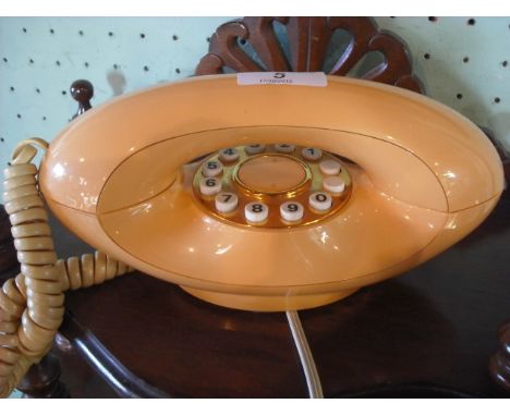 A late 20th century peach coloured push button telephone.