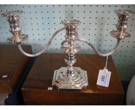 A late 20th century silver three branch candelabra, having twin reeded stems over columnar stem on shaped square base, Sheffi