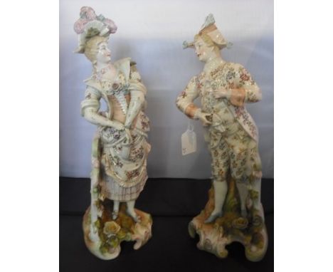 A pair of large 19th century Continental ceramic figurines, a dandy in tricorn hat and a finely dressed lady, each on florall