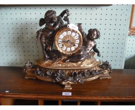 A 20th century French gilt mantle clock, surmounted by two putti, having applied floral garlands, the dial with inset enamel 