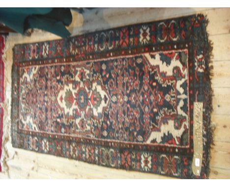 A hand made Persian carpet, having stylized floral forms on a blue ground, 172cm x 90cm.