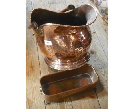 A late Victorian helmet shaped copper coal scuttle, together with a rectangular copper plant stand on four paw feet.