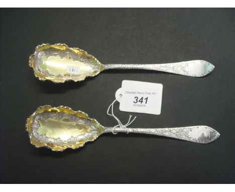 A pair of late 19th century silver and silver gilt serving spoons, the bowls with scallop edge, each decorated throughout, Sh