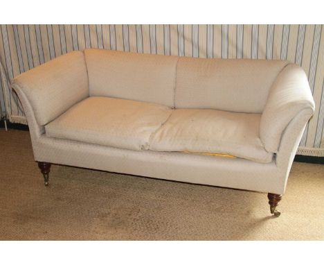 A Victorian mahogany framed three-seater sofa by Howard &amp; Sons, pale fabric upholstered, raised on ring turned squat tape