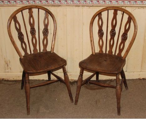 A pair of 19th century elm and yew splat and stick back kitchen chairs, having dished seats and raised on ring turned support