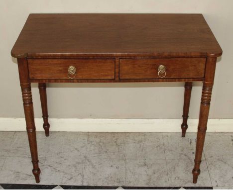 A Regency mahogany two drawer side table, having slightly proud rounded corners, raised on ring turned tapering supports, h.7