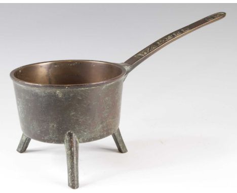 A 19th century bronze tripod skillet, the handle marked Warner 3P, 38.5cm, together with two pairs of brass candlesticks and 