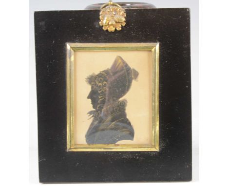 An early 19th century profile portrait silhouette of a middle-aged woman wearing a lace bonnet, 7.2 x 6cm; together with one 