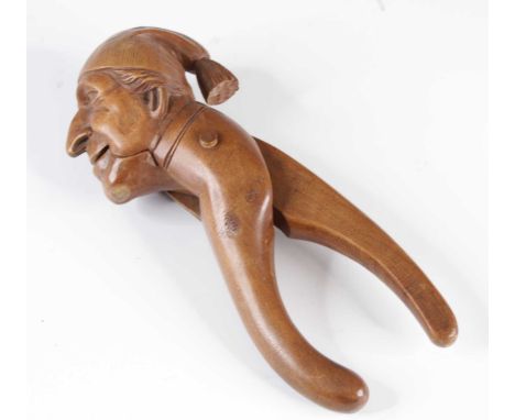 A 19th century fruitwood novelty nut cracker, of scissor action, the terminal carved in the form of Mr Punch, length 17cm.
