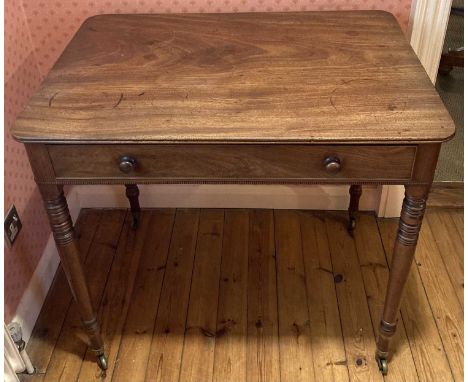 A Regency mahogany round cornered single drawer writing table, raised on ring turned supports to brass cup castors, h.76cm, w