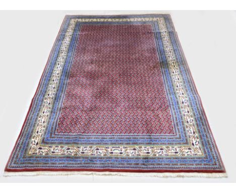 Large Persian hand-knotted carpet. Colour: red, with light blue border. Dimensions: 300 x 200 cm. In good condition.