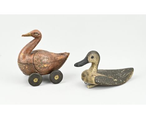 Two antique original wooden decoy ducks for hunting and other purposes. Polychromed. 1x with wheels (toy?). 1x With lead unde