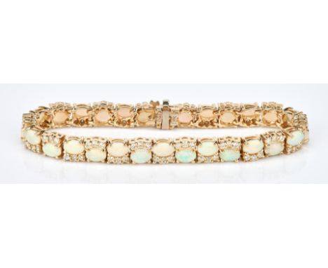 One ladies 14k yellow gold opal and diamond bracelet set with a total of 28 oval semi-crystal natural opal cabochons measurin