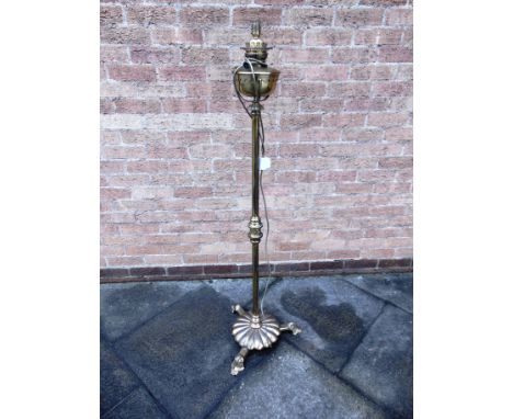 A BRASS PEDESTAL OIL LAMP  on circular base, converted to a floor lamp, height 138cm