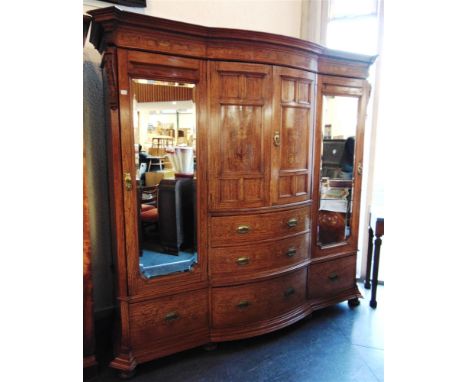 A LARGE VICTORIAN COMPACTUM the bow fronted central section with a pair of panelled doors enclosing three sliding press trays