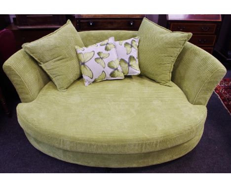 A modern DFS snuggle sofa in lime green with scatter cushions 