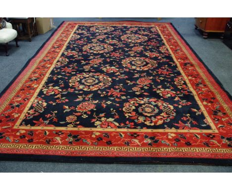 A large carpet floral decoration in hues of cream, taupe and salmon on a black ground with red border. approximately 500cm x 