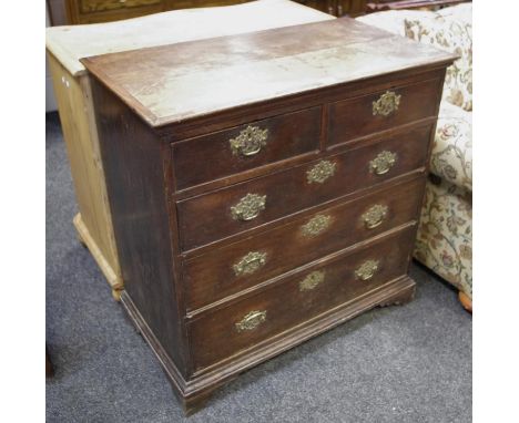 An oak chest of two short drawers over three graduated long, pierced brass batwing escutcheons, bracket feet, circa 1810
