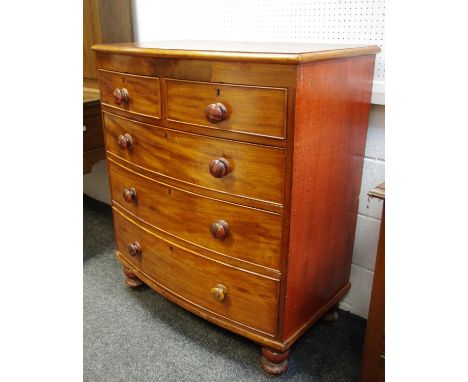 A Victorian mahogany bowfront chest, two cockbeaded short drawers over three graduated long drawers, button handles, turned f