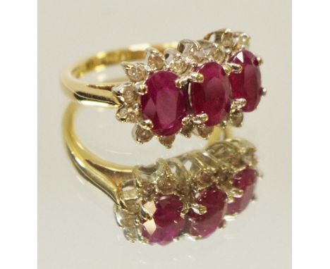 A 9ct golf ring set with three oval rubies and 0.5ct of diamonds, 6.6g gross