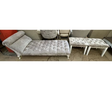 An upholstered day bed with a shaped back and button back upholstery on cabriole legs together with a pair of similarly uphol