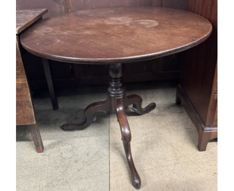 A 19th century mahogany tripod table with a circular top on a turned column