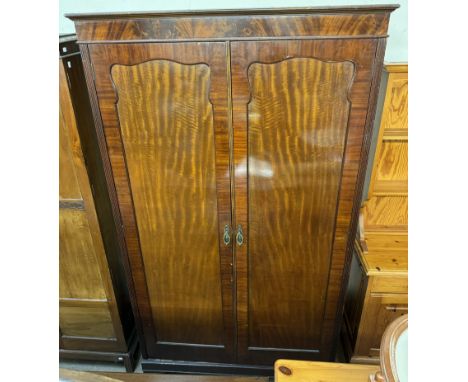 An Edwardian mahogany wardrobe with a moulded cornice above a pair of cupboard doors on bracket feet